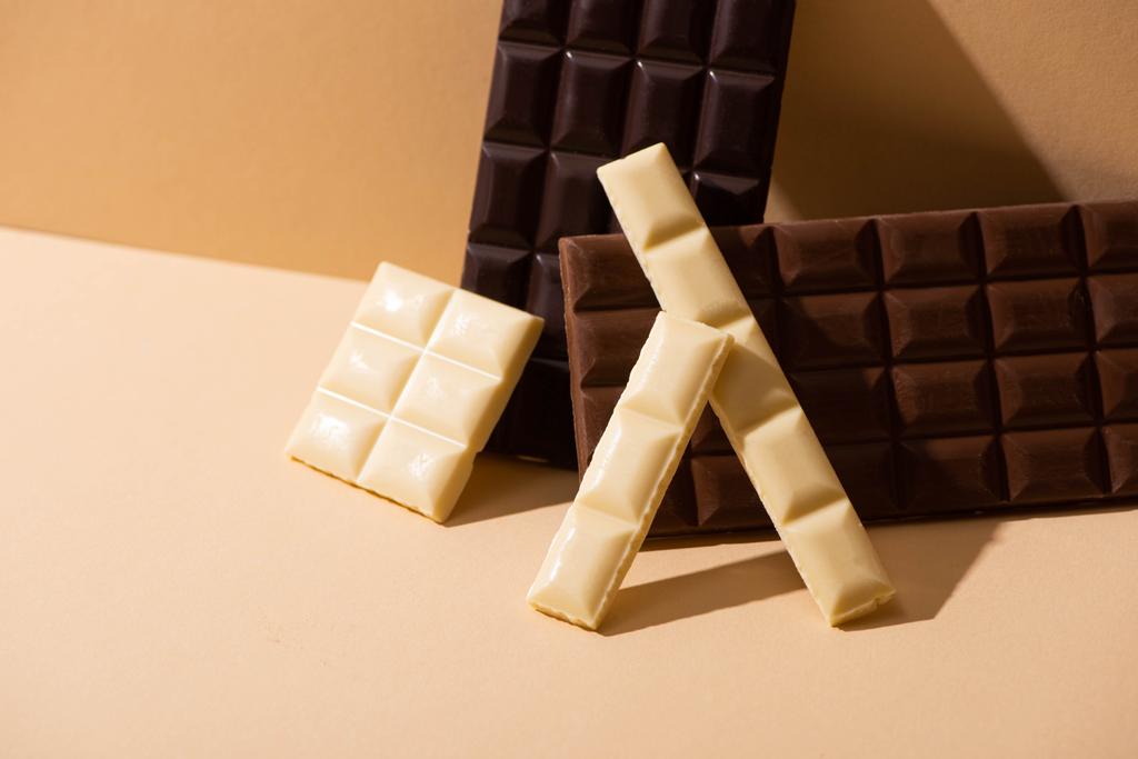 солодкий смачний темний, молочний і білий шоколад на бежевому фоні
 - Фото, зображення