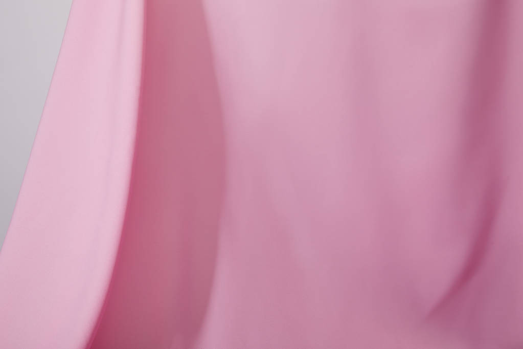 στενή άποψη του ροζ μαλακό κυματιστό ύφασμα που απομονώνονται σε γκρι - Φωτογραφία, εικόνα