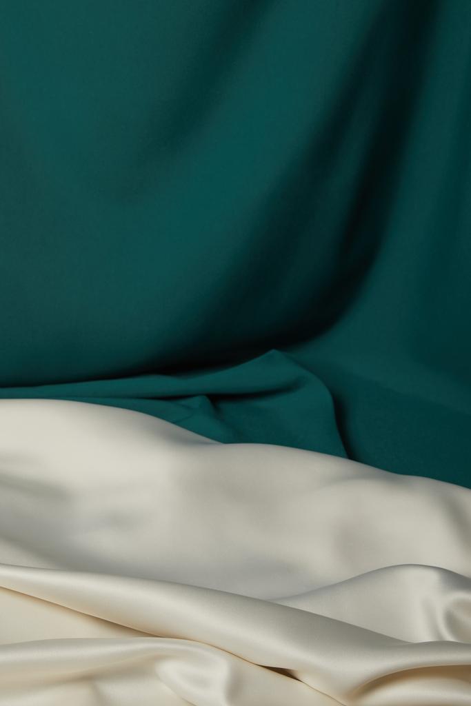 close-up van smaragd en wit zachte en golvende zijden stof - Foto, afbeelding