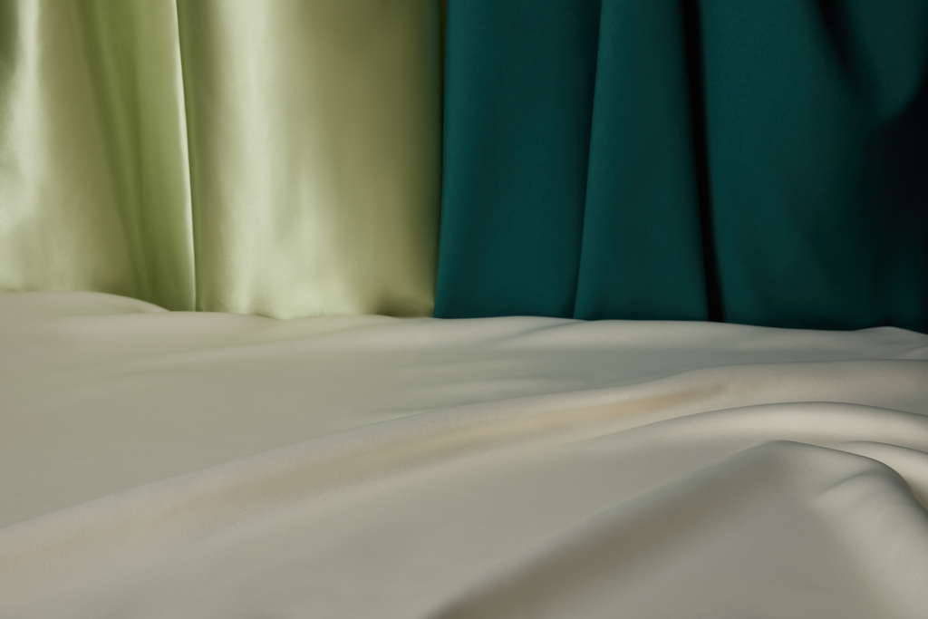 крупним планом вид смарагдової, світло-зеленої та білої м'якої та хвилястої шовкової тканини
 - Фото, зображення