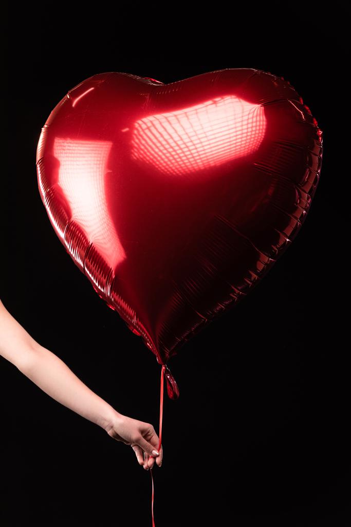 vista ritagliata di donna che tiene palloncino a forma di cuore in 14 febbraio isolato su nero
 - Foto, immagini