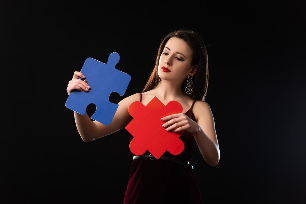 attente vrouw in jurk houden puzzel cijfers geïsoleerd op zwart - Foto, afbeelding