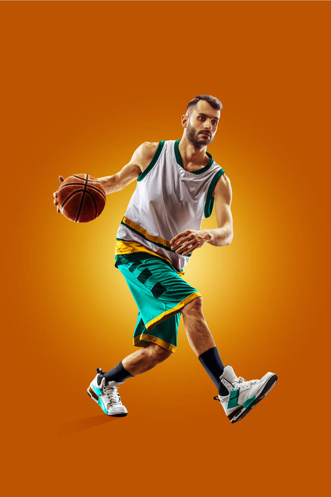 bright professional basketball player on an orange background - Fotoğraf, Görsel