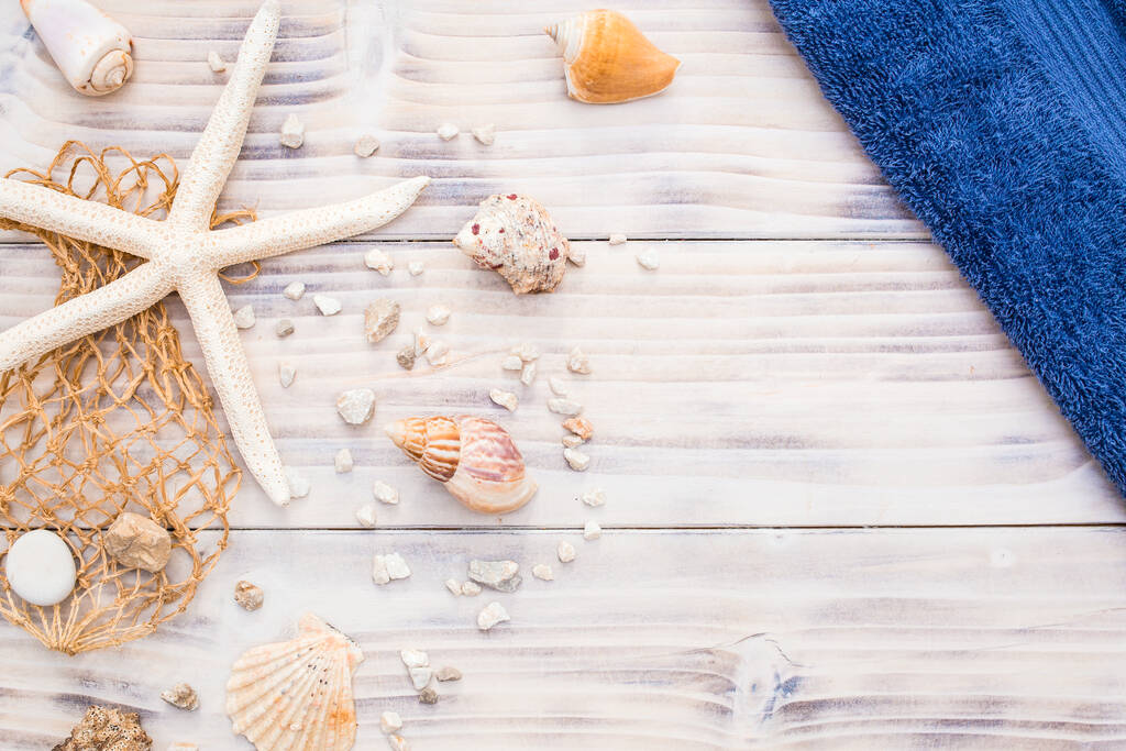 Starfish com conchas do mar sobre fundo de madeira branco. Verão, conceito de férias, lembrança com toalha azul
 - Foto, Imagem