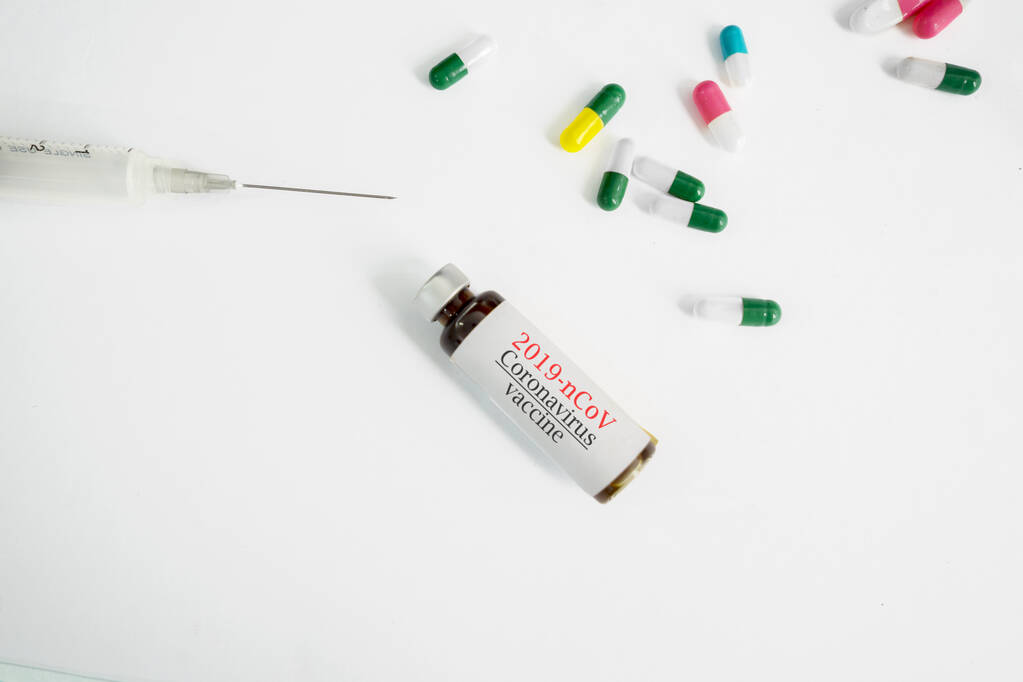 Coronavirus outbreak concept: medical stethoscope, syringe, coronavirus vaccine bottle and pills isolated over white background - Photo, Image