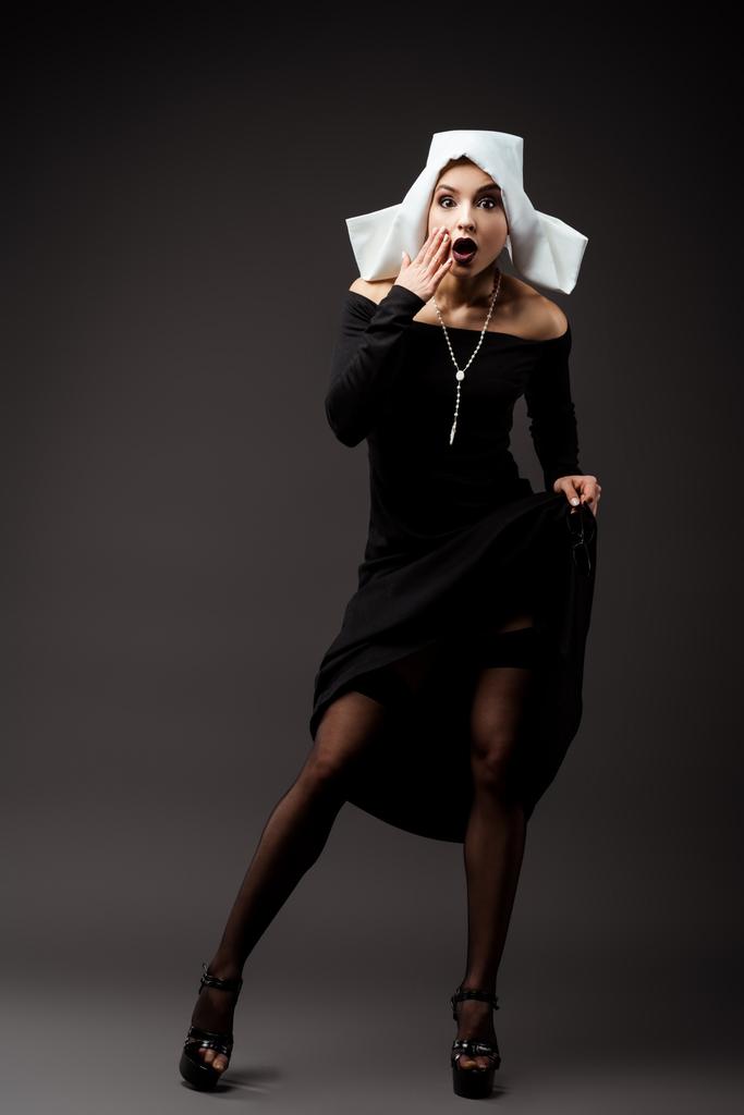 chocado sexy freira no preto vestido e meias, no cinza
 - Foto, Imagem