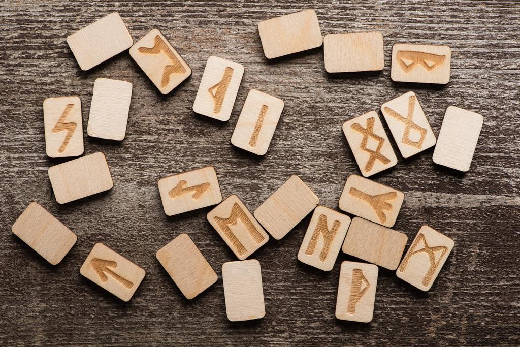 Pohled shora na dřevěné runy s etnickými znaky na dřevěném povrchu - Fotografie, Obrázek