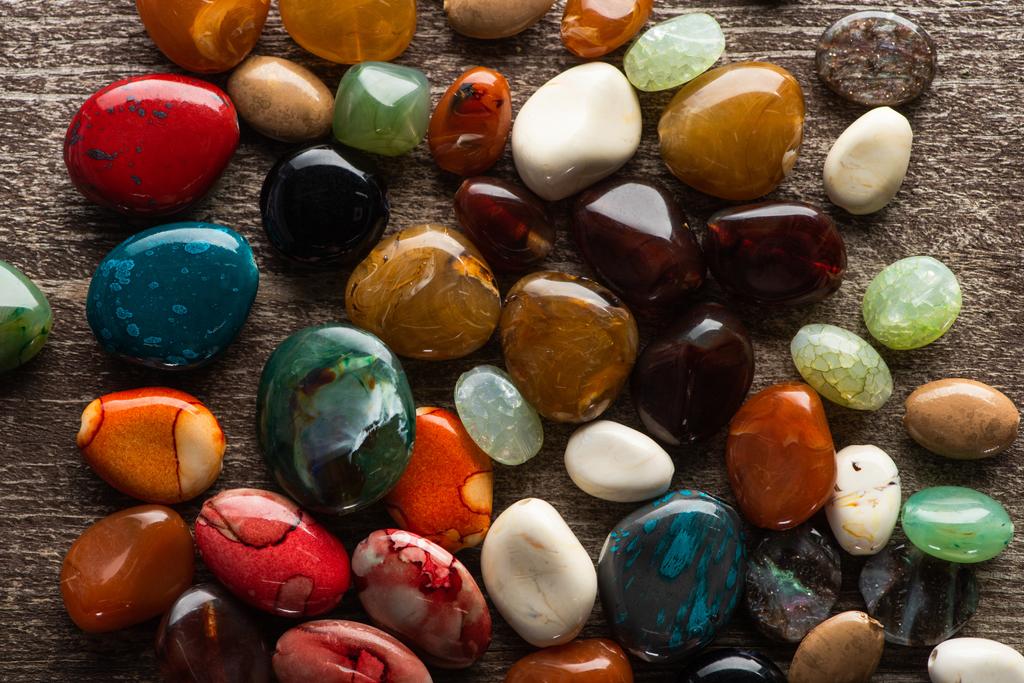 Top view of colorful fortune telling stones on wooden background - Photo, Image