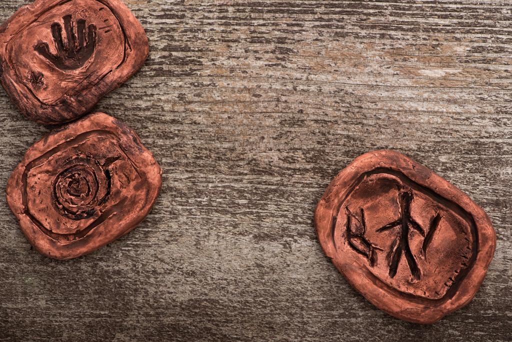 Vue du dessus des symboles sur l'argile chamanique talismans sur la surface en bois
 - Photo, image