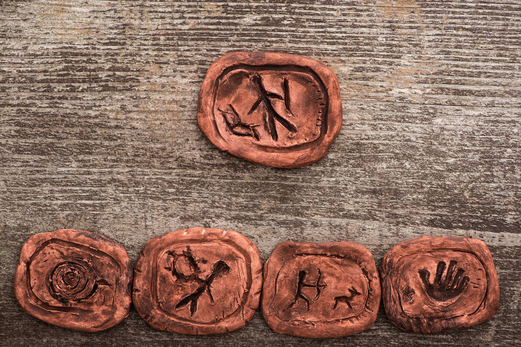 Top view of shamanic clay amulets on wooden background - Photo, Image