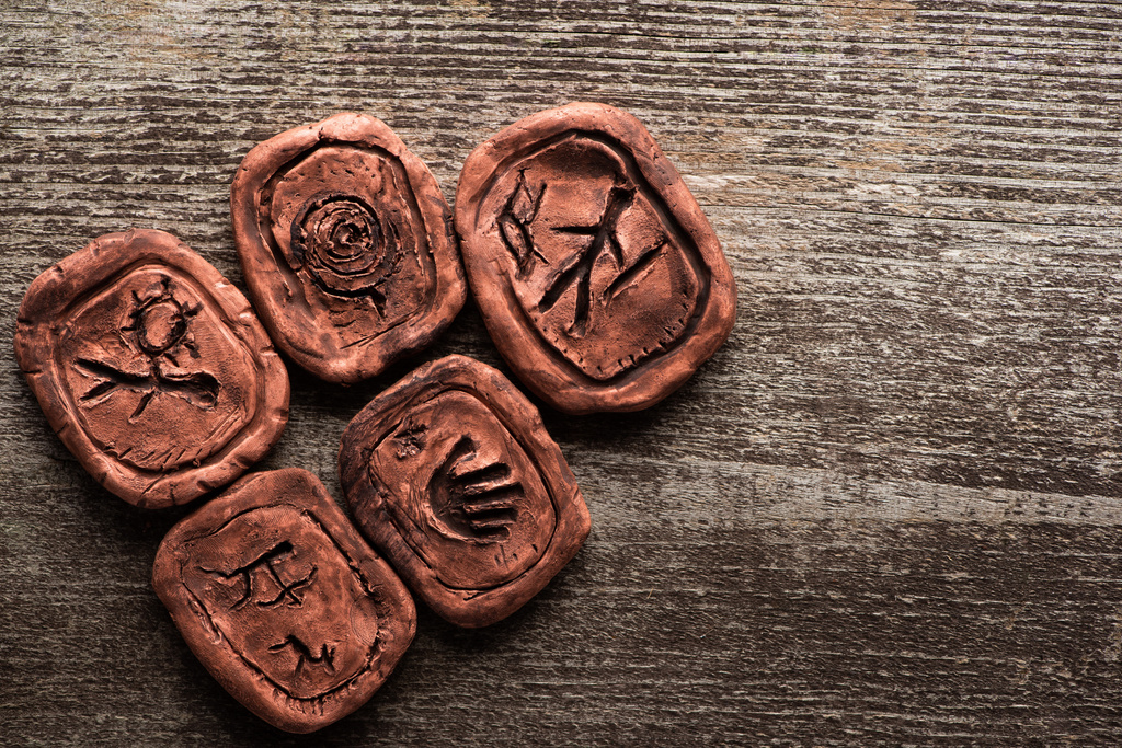 Vista superior de talismanes de arcilla con letreros sobre fondo de madera con espacio para copiar
 - Foto, imagen