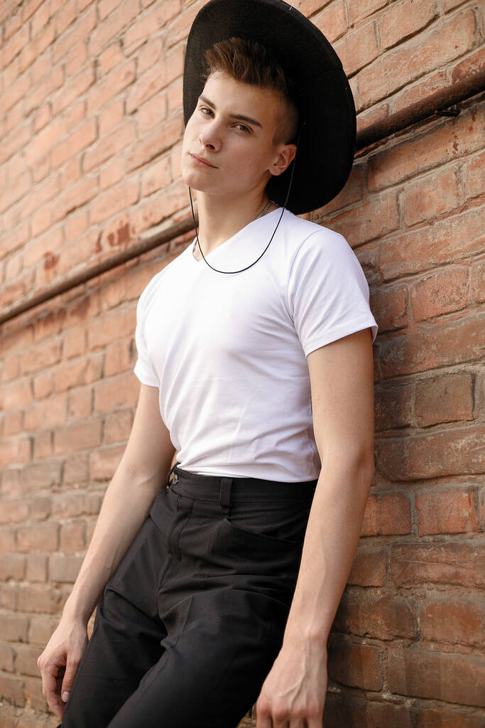 muotokuva trendikäs nuori mies kaupungissa. lähikuva muotokuva kaveri malli musta hattu tiiliseinä tausta
 - Valokuva, kuva