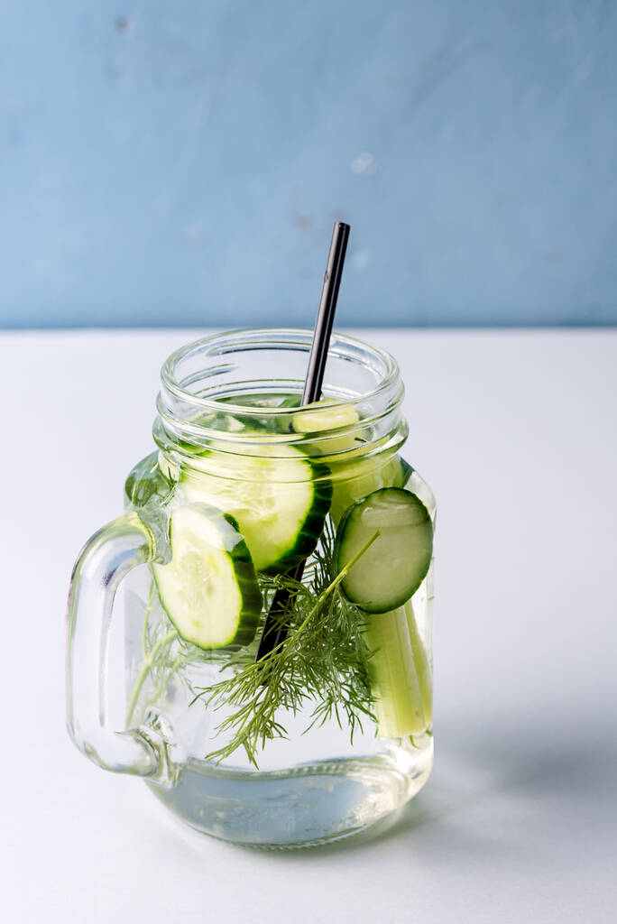 Tarro de vidrio de sabrosa agua infundida fresca hecha con pepino vegetal orgánico y apio saludable bebida de desintoxicación
 - Foto, Imagen
