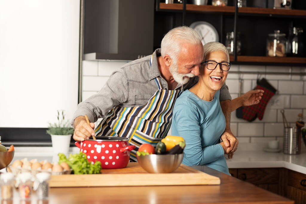 Старшая флиртовая пара веселится на кухне, прекрасная пенсия - Фото, изображение