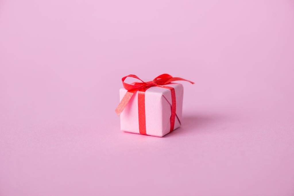 pequeno papel presente com fita e arco em rosa
  - Foto, Imagem
