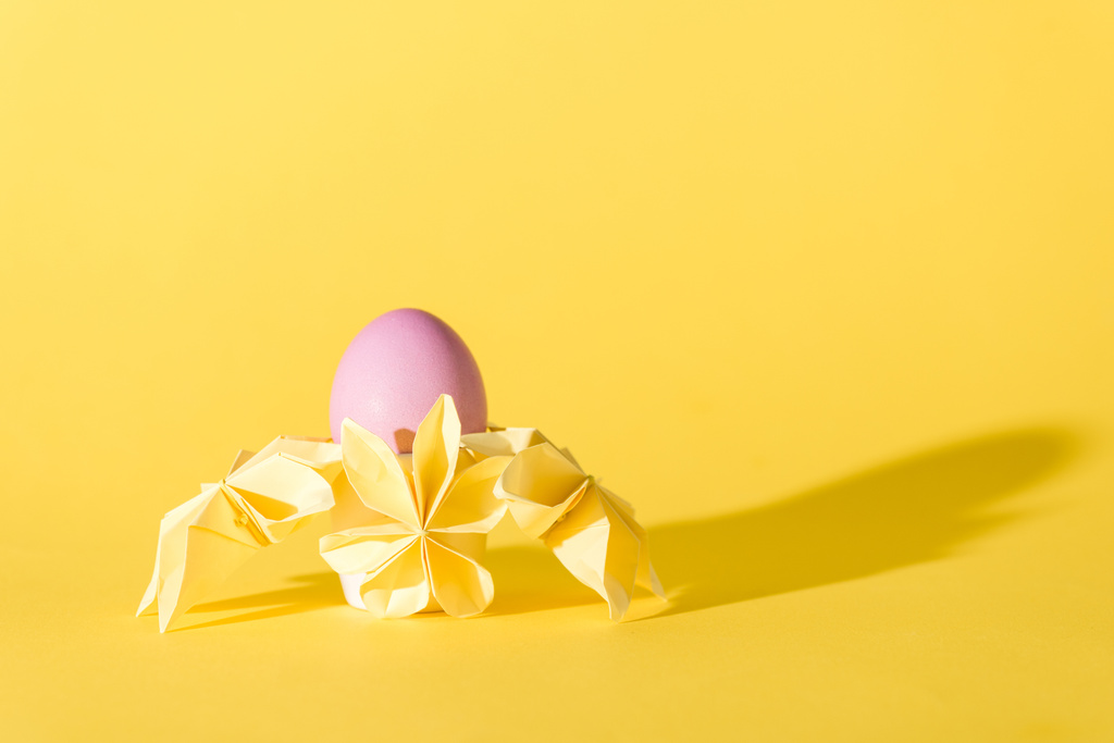 origami λουλούδια κοντά ζωγραφισμένα πασχαλινό αυγό σε κίτρινο με χώρο αντίγραφο  - Φωτογραφία, εικόνα