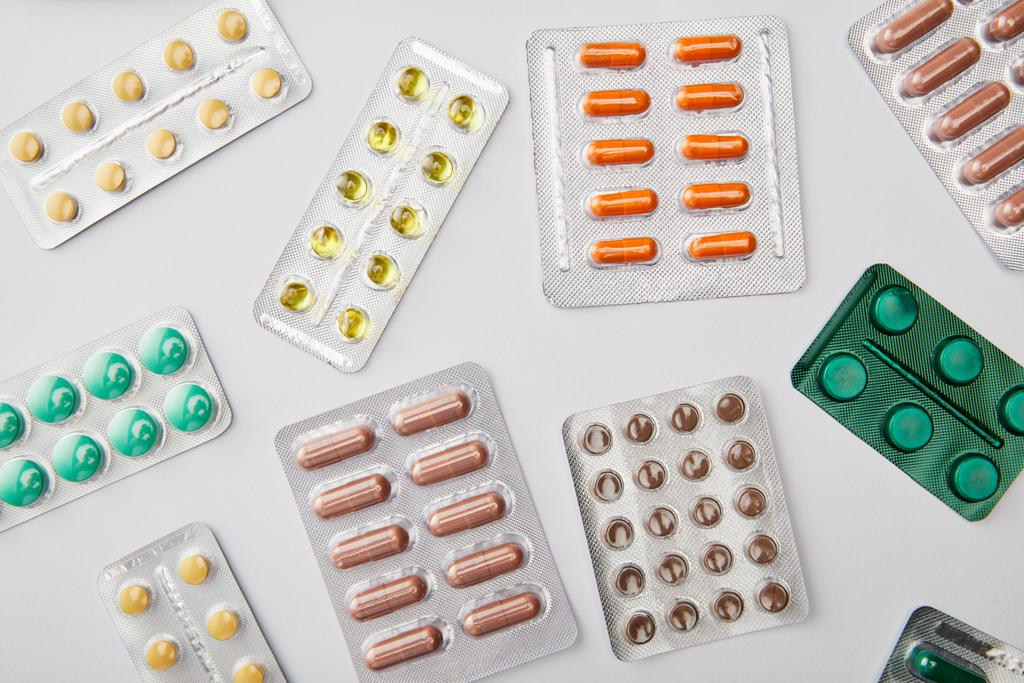 Вид сверху на различные таблетки на белом фоне
 - Фото, изображение