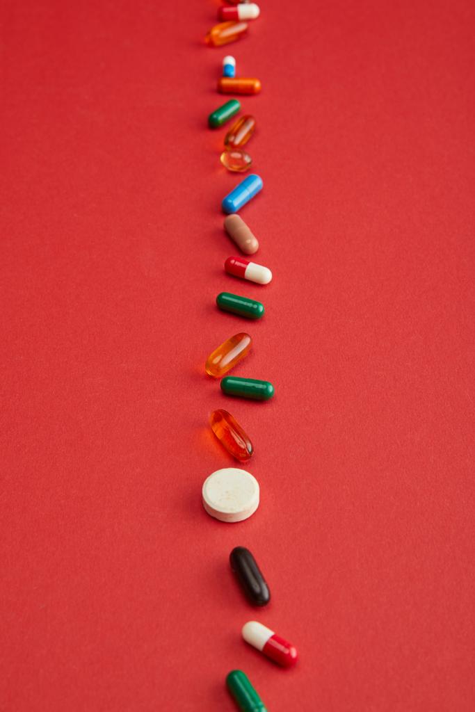 Высокий угол обзора ярких таблеток на красном фоне
 - Фото, изображение