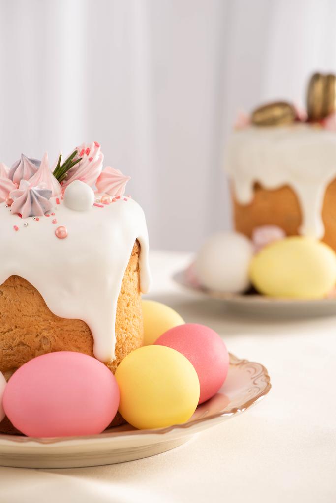 enfoque selectivo de deliciosos pasteles de Pascua con merengue y huevos de colores en los platos
 - Foto, imagen