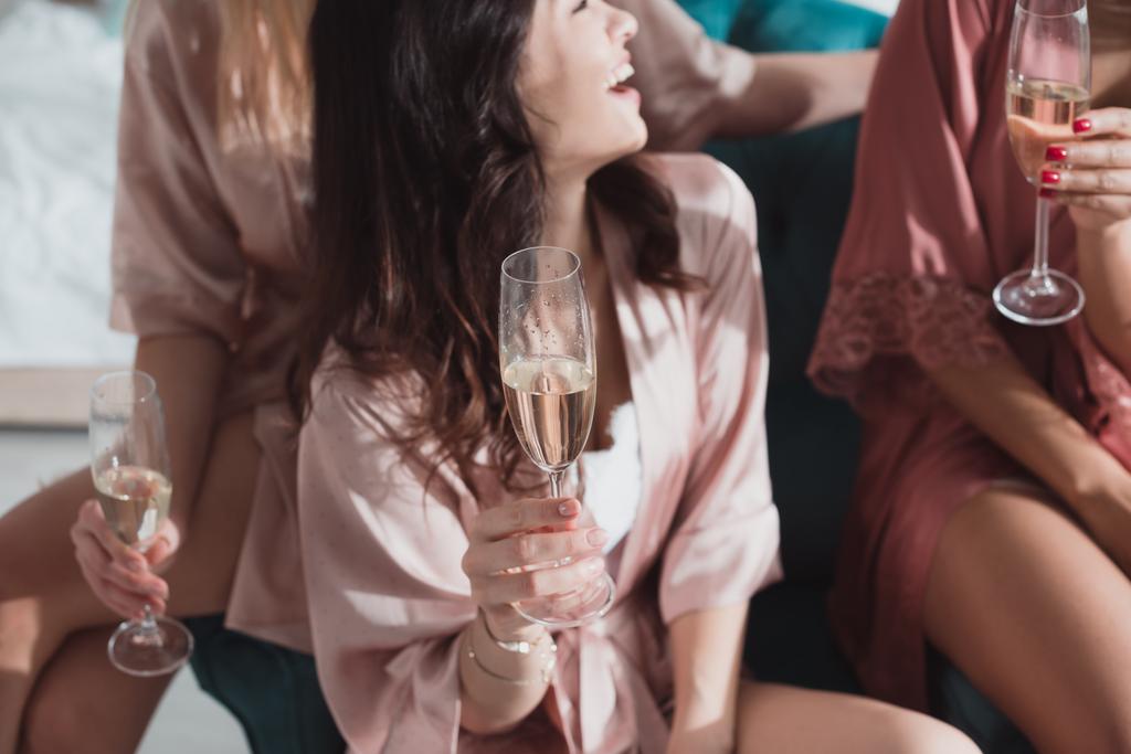 Vue recadrée d'amis multiculturels heureux avec des verres de champagne à la fête de célibataire dans la chambre
 - Photo, image