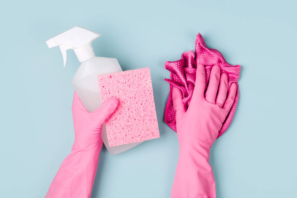 Ręce w rękawiczkach różowy przechowywania detergentów. Czyszczenie i sprzątanie koncepcja tła. Kopiować miejsca. Widok płaski świeckich, Top. - Zdjęcie, obraz