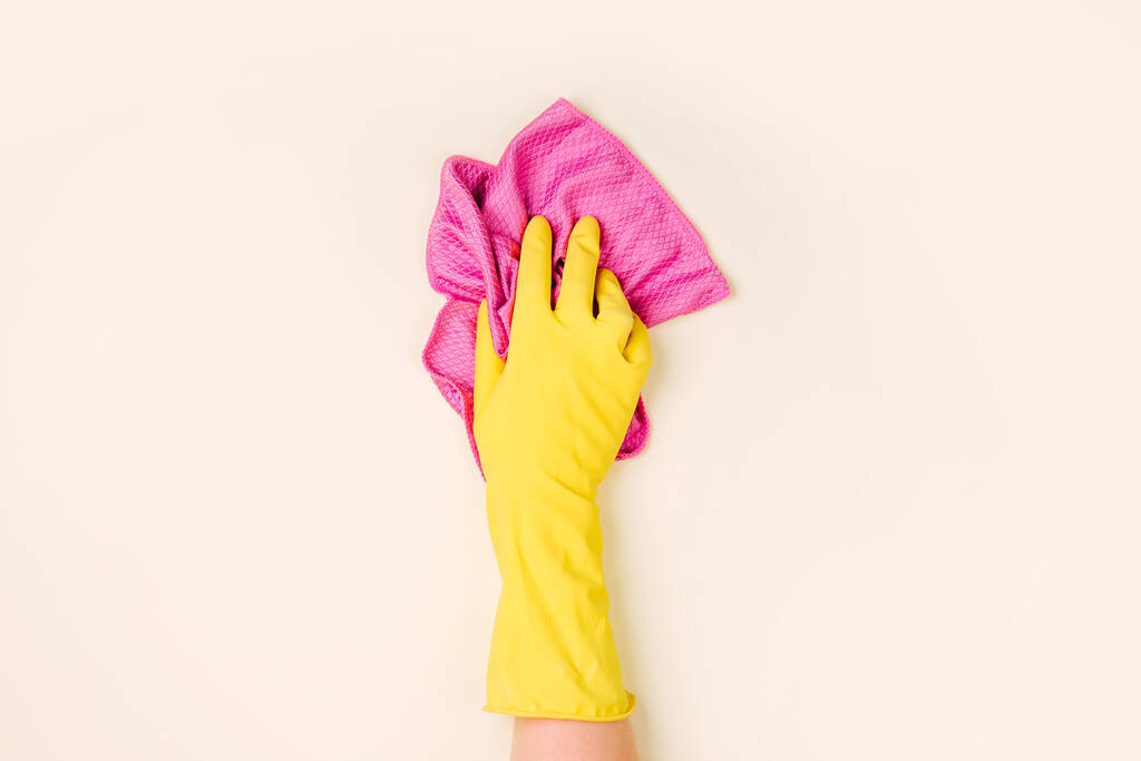  Weibliche Hände beim Putzen auf blassgelbem Hintergrund. Hintergrund des Reinigungs- oder Reinigungskonzepts. Kopierraum. Flache Lage, Draufsicht. - Foto, Bild