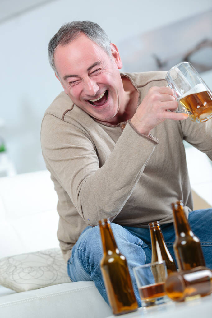 keski-ikäinen mies juo olutta
 - Valokuva, kuva