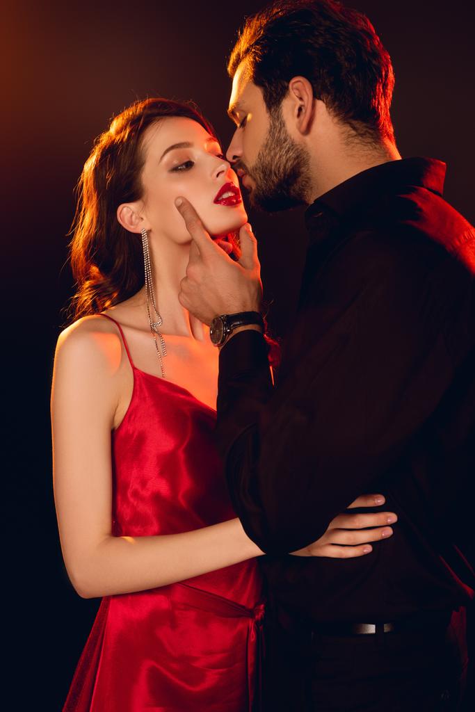 Jóképű férfi csók elegáns barátnő piros ajkak elszigetelt fekete - Fotó, kép