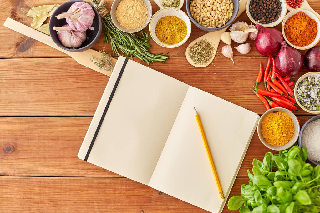 notebook with pencil among spices on wooden table - Photo, Image