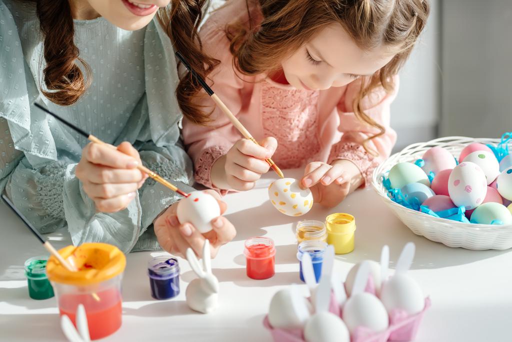избирательный фокус счастливой матери и милой дочери живописи пасхальные яйца вблизи декоративных кроликов
  - Фото, изображение
