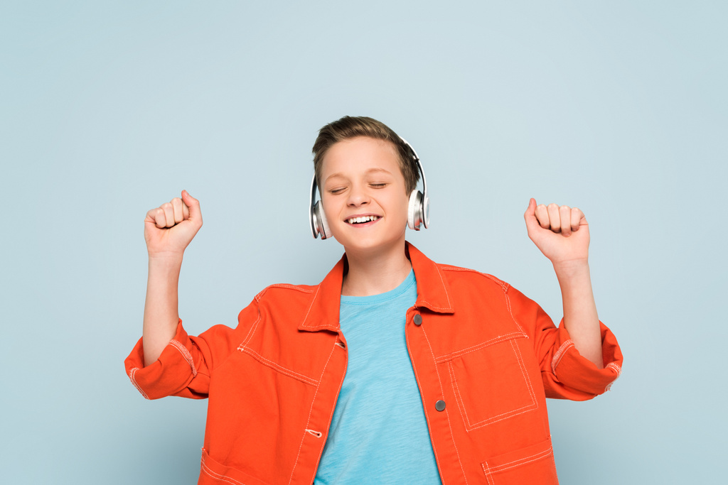 hymyilevä poika kuulokkeet kuunnella musiikkia sinisellä taustalla
  - Valokuva, kuva