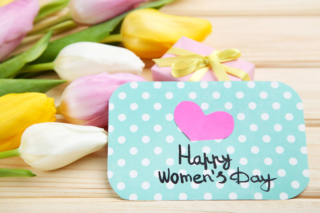 Text Happy Womens Day with tulip flowers on brown wooden table - Photo, Image