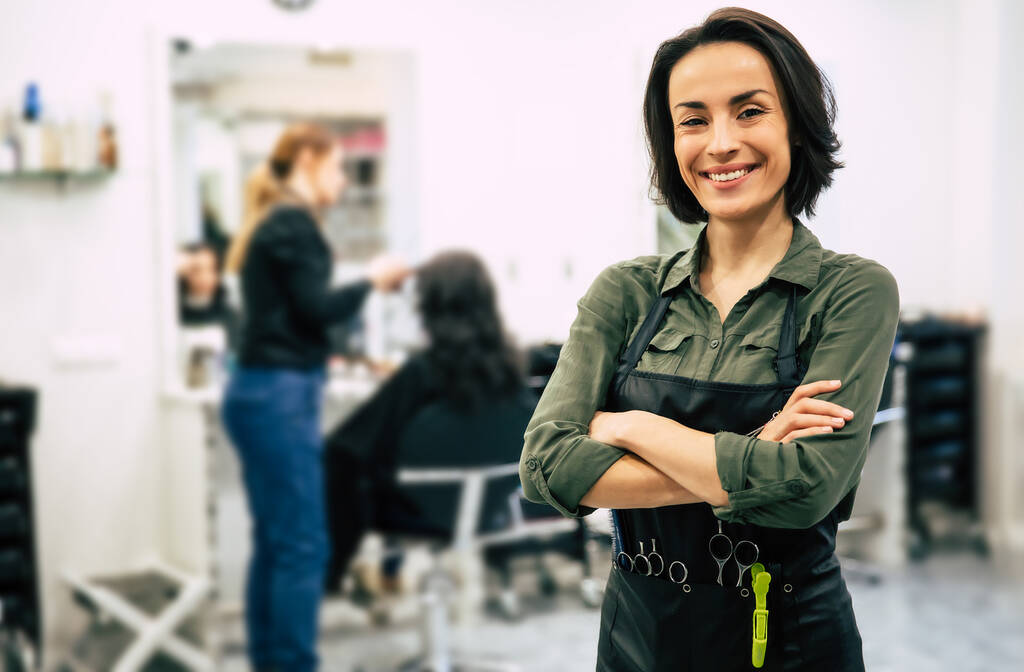 portrait of beautiful young hairdresser in salon - Photo, Image