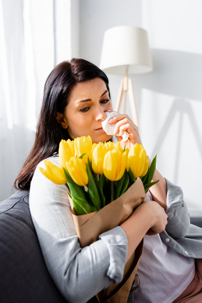sad woman with pollen allergy looking at tulips  - Photo, Image