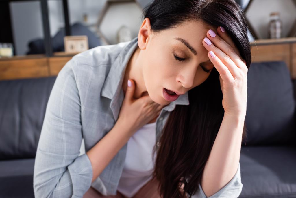 mulher asmática com olhos fechados tocando pescoço em casa
  - Foto, Imagem