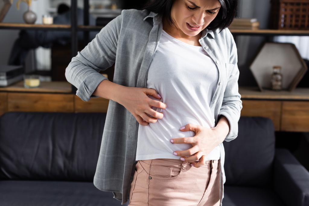 rozstrój kobieta z alergią drapanie żołądka w domu  - Zdjęcie, obraz