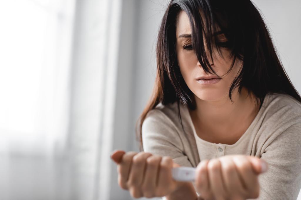 Selektiver Fokus enttäuschter Frau mit negativem Schwangerschaftstest  - Foto, Bild