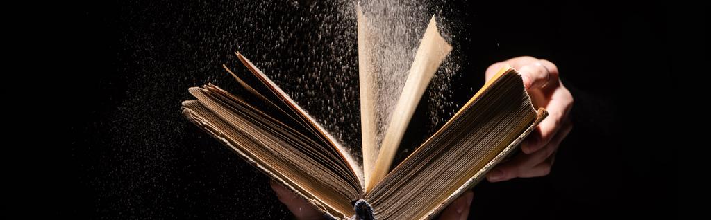 cropped view of woman holding holy bible with dust on black background, panoramic shot - Photo, Image