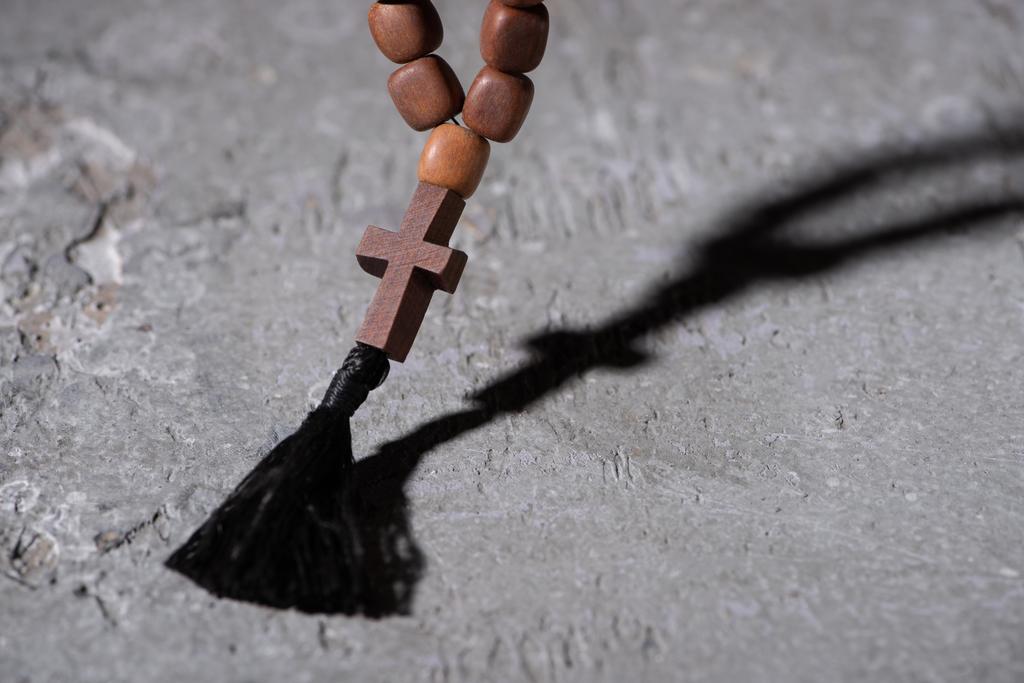 dřevěný růženec s křížem na šedé texturované ploše - Fotografie, Obrázek