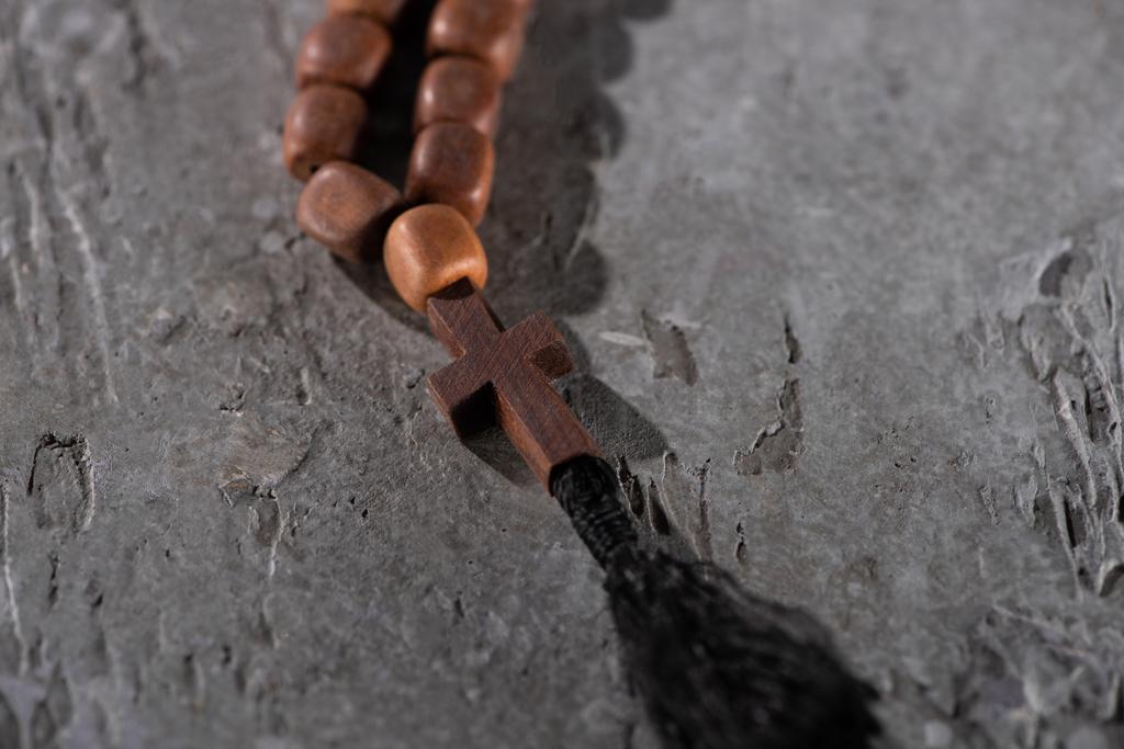 rosário de madeira com cruz na superfície texturizada cinza
 - Foto, Imagem