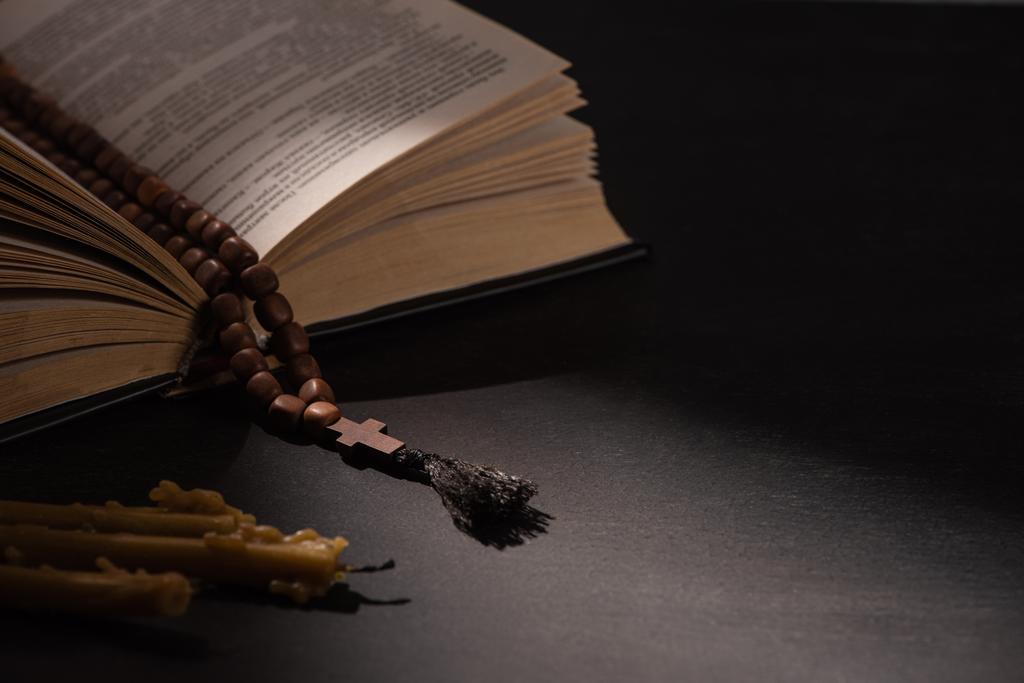 священна Біблія з розарієм на чорному темному фоні зі свічками
 - Фото, зображення