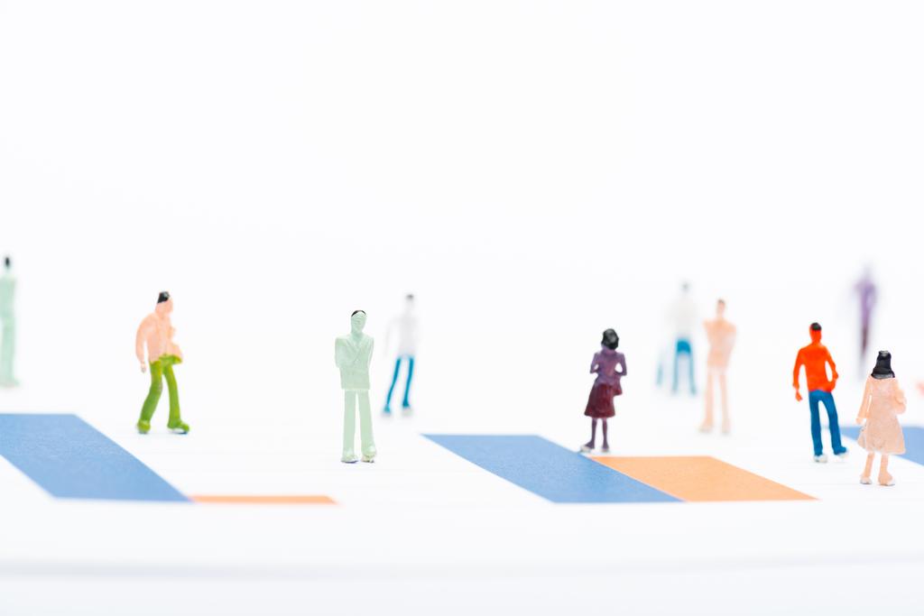 Foco seletivo de figuras de pessoas na superfície com gráficos isolados em branco, conceito de igualdade
 - Foto, Imagem