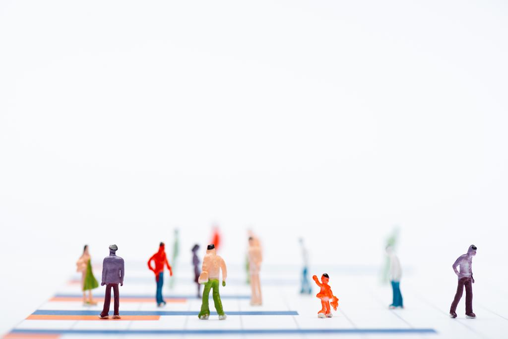 Vista de perto de figuras de pessoas de plástico na superfície com gráficos isolados em branco, conceito de igualdade
 - Foto, Imagem