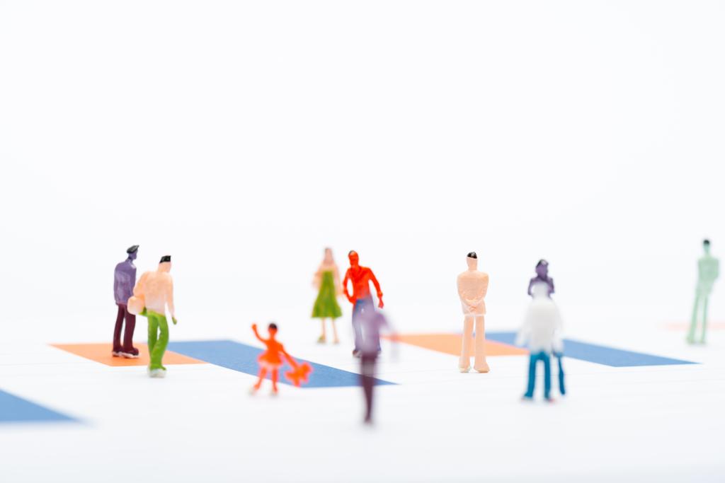 Вибірковий фокус пластикових людей фігури на поверхні з графіками ізольовані на білому, концепція рівності
 - Фото, зображення