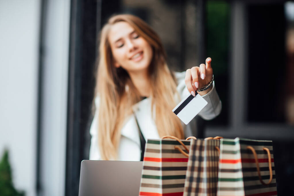 Portret van een vrouw die boodschappen doet met haar creditcard, cadeautjes koopt voor iemand. Sluiten.. - Foto, afbeelding