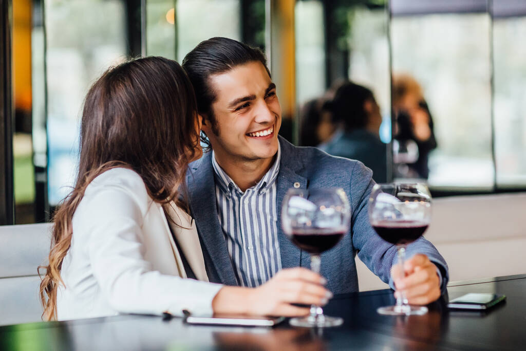 Romantický mladý pár těší večeři v kavárně, vztah a romantické době, šťastný slaví a dělat radost s brýlemi červeného vína. - Fotografie, Obrázek
