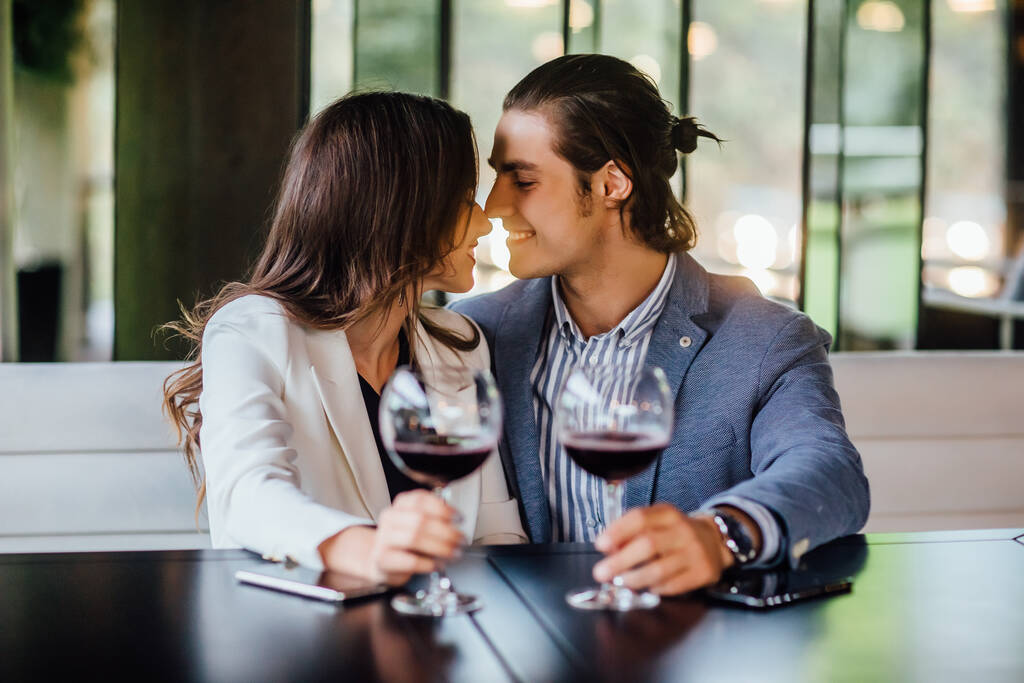 Romantikus pár élvezi a vacsorát kávézóban, kapcsolat és romantikus idő, boldog ünneplés és éljenzés pohár vörösbor. - Fotó, kép