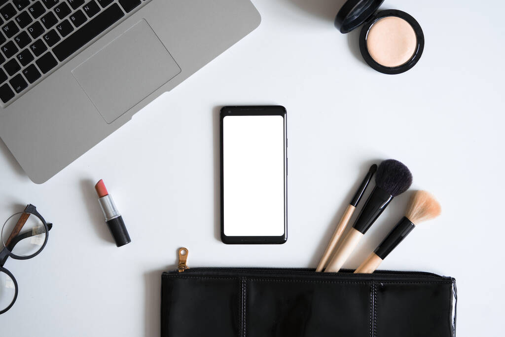 Makeup Bag With Spilling Out Cosmetic Beauty Products Near Laptop And Mobile Phone With Blank Screen. Bag Content Of Independent Woman - Fotoğraf, Görsel