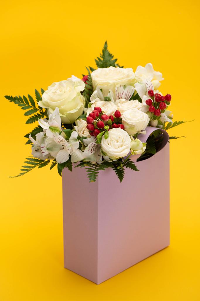 primavera bouquet fresco di fiori in sacchetto di carta viola su giallo
 - Foto, immagini