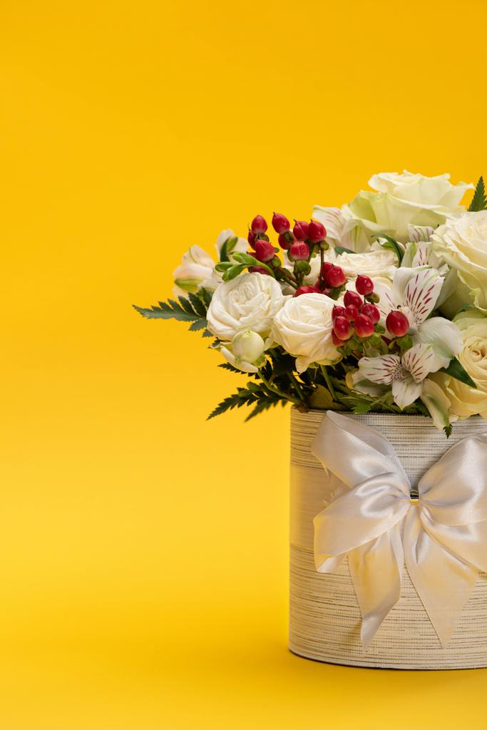 весняний свіжий букет квітів у святковій подарунковій коробці з бантом на жовтому
 - Фото, зображення